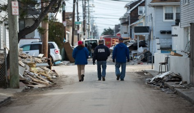 Three FEMA employees walking the street after a natural disaster.